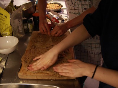 Image description: a messy kitchen work surface with four hands patting down a freshly made seitan dough.  Maria Guggenbichler & School in Common, Intimacy Manifesto, 2018. Photo: School in Common